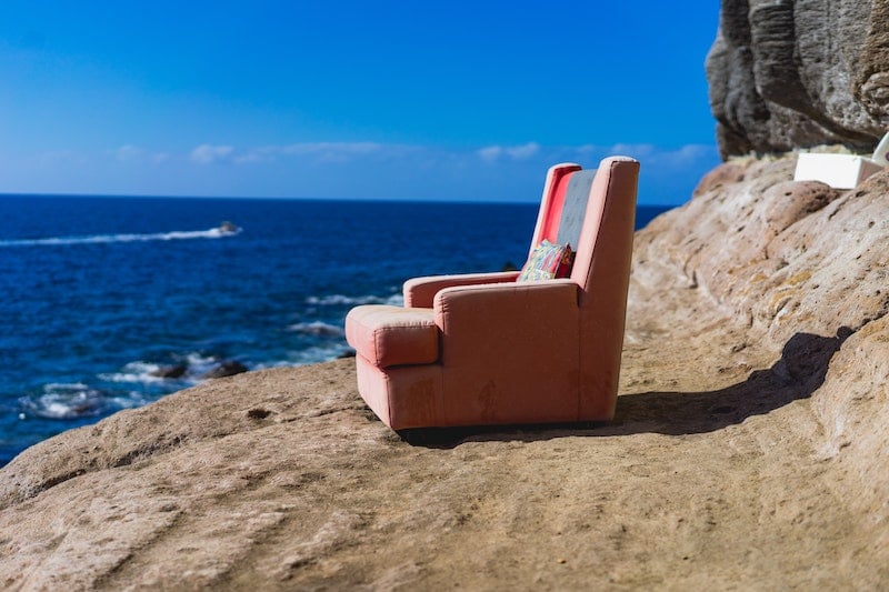 pink sofa chair near a body of water